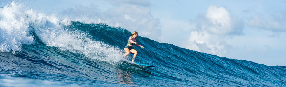 Woman surfing in Maldives